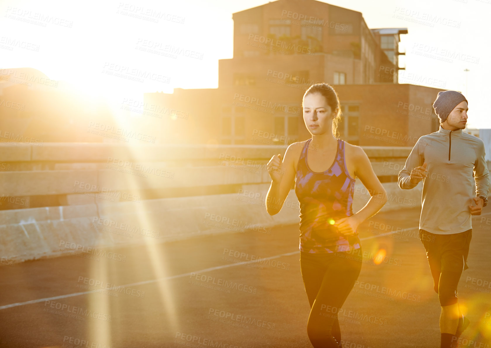 Buy stock photo Running, man and woman in urban sunset for fitness, training and commitment to healthy body. Evening, exercise and athlete couple on road for city workout, outdoor challenge or sports performance