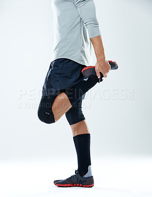 Buy stock photo Cropped shot of a man stretching his legs over a white background