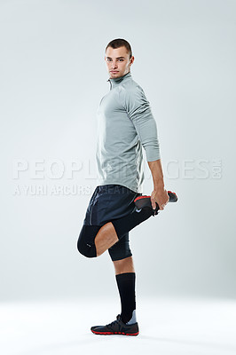 Buy stock photo Portrait of a young man doing stretches in a studio