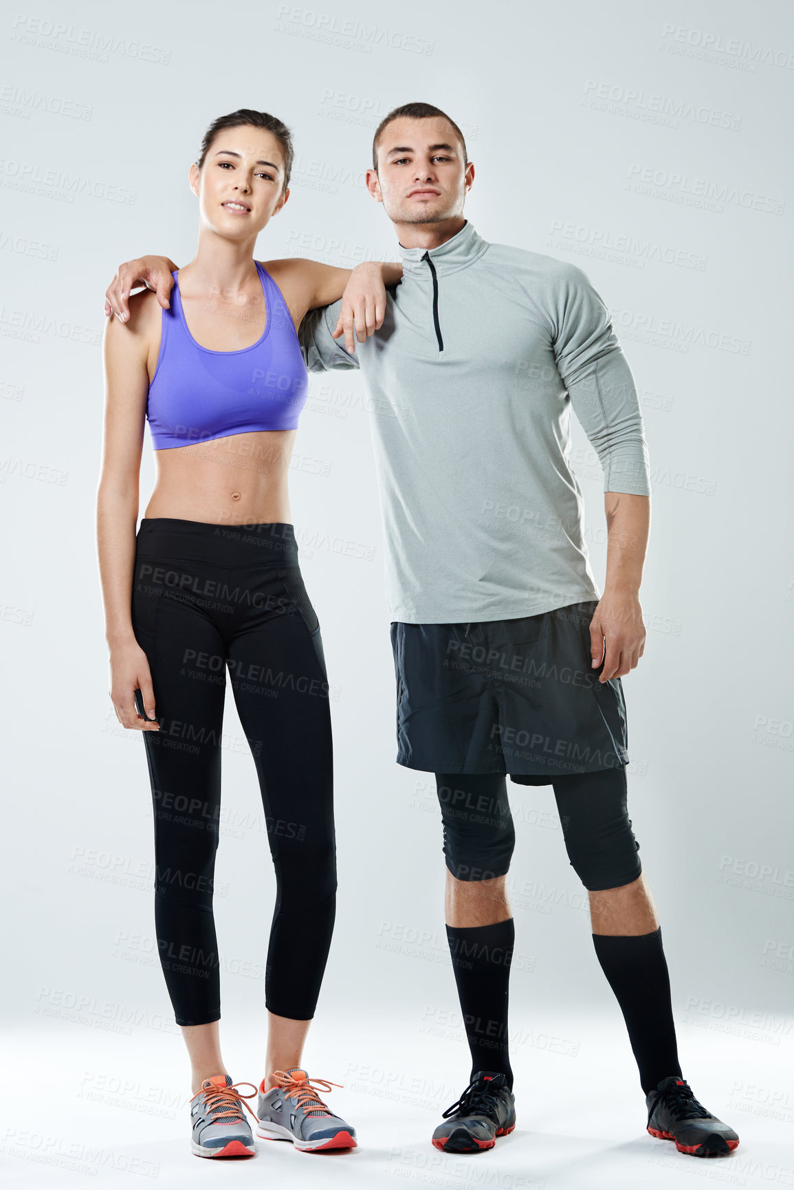 Buy stock photo Portrait of a young athletic couple standing in a studio