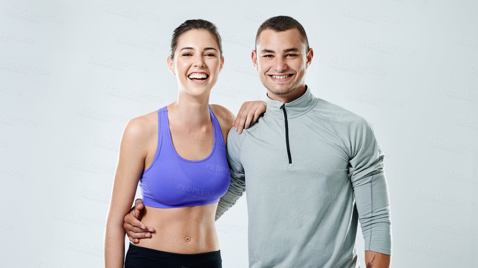 Buy stock photo Portrait of a sporty young couple standing against a gray background