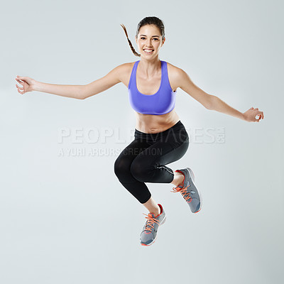 Buy stock photo Woman, exercise and jump with portrait in studio for healthy body, fitness and muscle strength. Happy, person and athlete with workout in air for training, energy and self care by white background