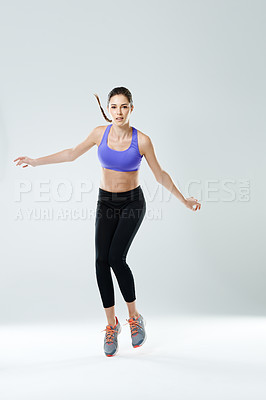 Buy stock photo Woman, workout and jump with portrait in studio for healthy body, fitness and muscle strength. Person, serious and athlete with exercise in air for energy, training and self care by white background