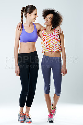 Buy stock photo Two woman looking at each other while wearing sports clothing in a studio