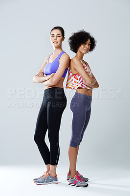 Buy stock photo Shot of two woman standing in a studio wearing sports clothing