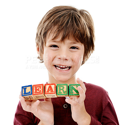 Buy stock photo Studio shot of a cute little boy holding building blocks that spell the world 'learn' against a white background