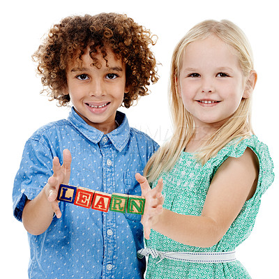 Buy stock photo Studio shot of a cute little boy and girl holding building blocks that spell the world 'learn' against a white background