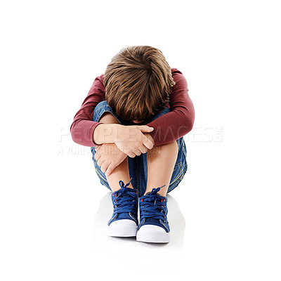Buy stock photo Studio shot of a little boy with his head buried in his knees against a white background