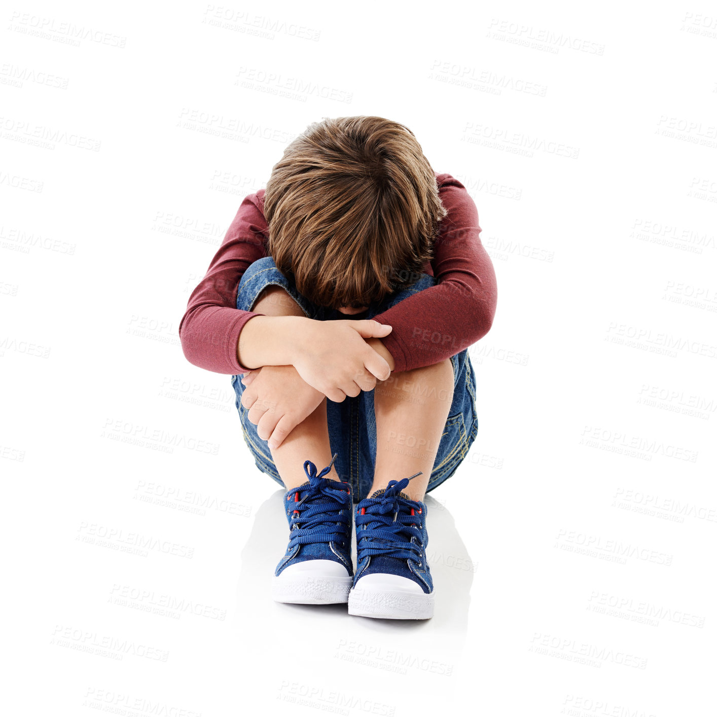 Buy stock photo Studio shot of a little boy with his head buried in his knees against a white background