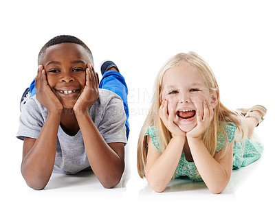 Buy stock photo Happy, portrait and interracial children with funny face for childhood, youth or development on a white studio background. Young, kids or boy and girl lying with smile on floor for break or rest