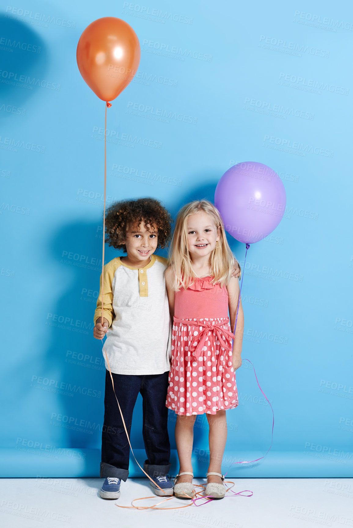 Buy stock photo Portrait of a cute little girl and boy holding a balloon over a blue background