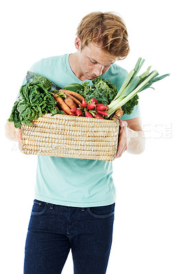 Buy stock photo Man, smell vegetables and basket in studio, shopping and organic produce by white background. Person, thinking and container with groceries, nutrition or scent for vegan food with discount for diet