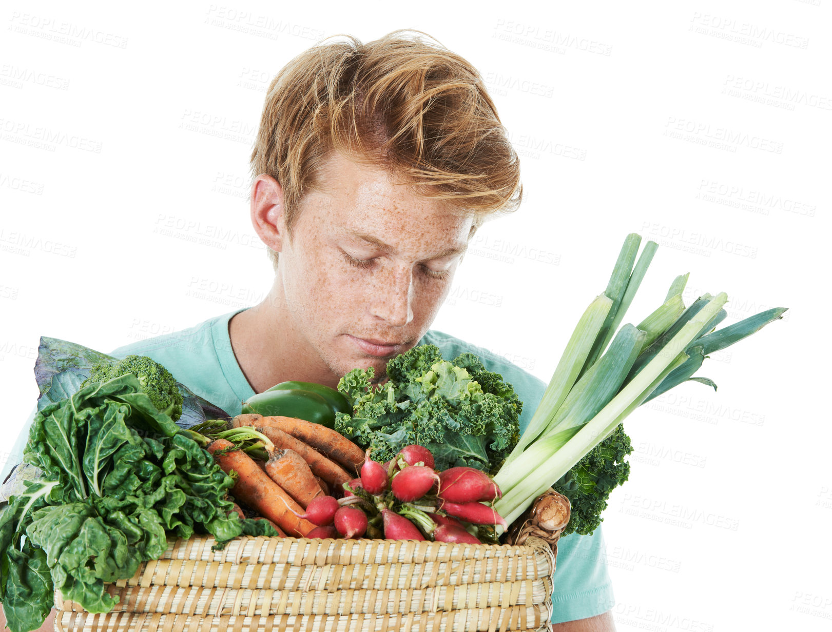 Buy stock photo A handsome young red-headed man smelling a basket of fresh vegetable produce