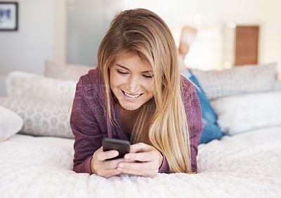 Buy stock photo Teenager, girl and smartphone with social media and relax in bedroom, smile with technology and communication. Young female person at home, using phone and mobile app with happiness, gen z and chat