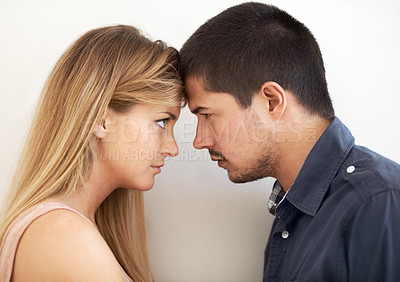 Buy stock photo Serious young couple looking intently at one another