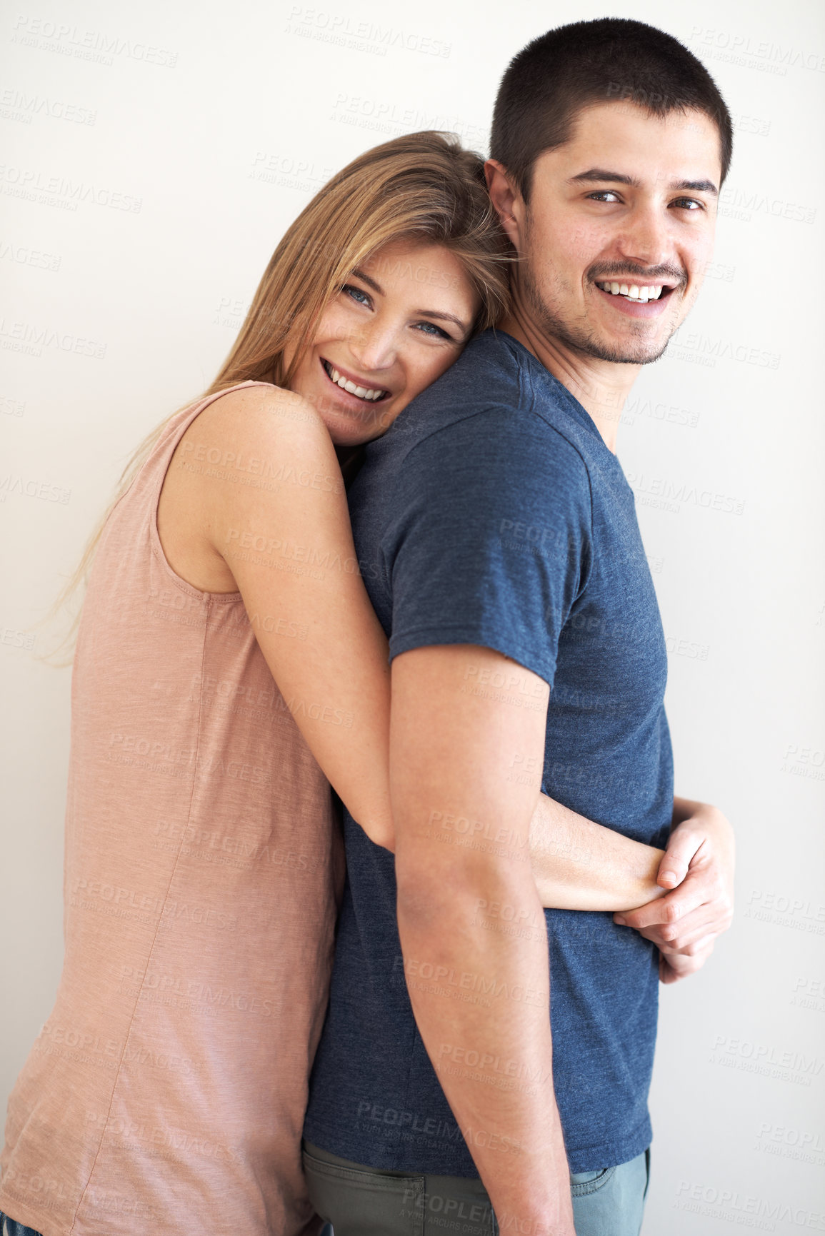 Buy stock photo Portrait, hug and couple in studio happy, bonding and having fun against a wall background. Face, smile and woman embracing man with care, romance and love while enjoying their relationship together
