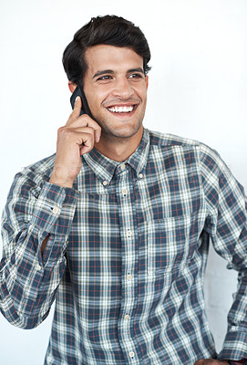 Buy stock photo Smile, phone call and creative designer in studio on white background for communication, networking and chat. Man, conversation and happy person speaking on smartphone for contact, discussion or talk