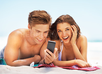 Buy stock photo Happy, music and a couple at the beach with a phone for a podcast, radio or social media in Mexico. Smile, relax and a man and woman with mobile app for audio during a holiday by the ocean in summer