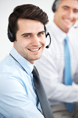 Buy stock photo Male customer service agents at work while wearing headsets