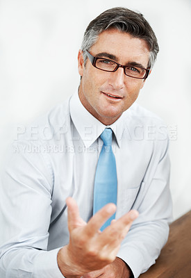 Buy stock photo Handsome mature businessman wearing glasses and explaining something to you 