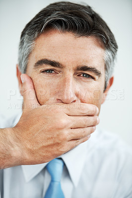 Buy stock photo Mature businessman covering his mouth with his hand