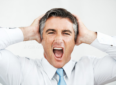 Buy stock photo Frustrated mature businessman with his hands on his head while yelling 