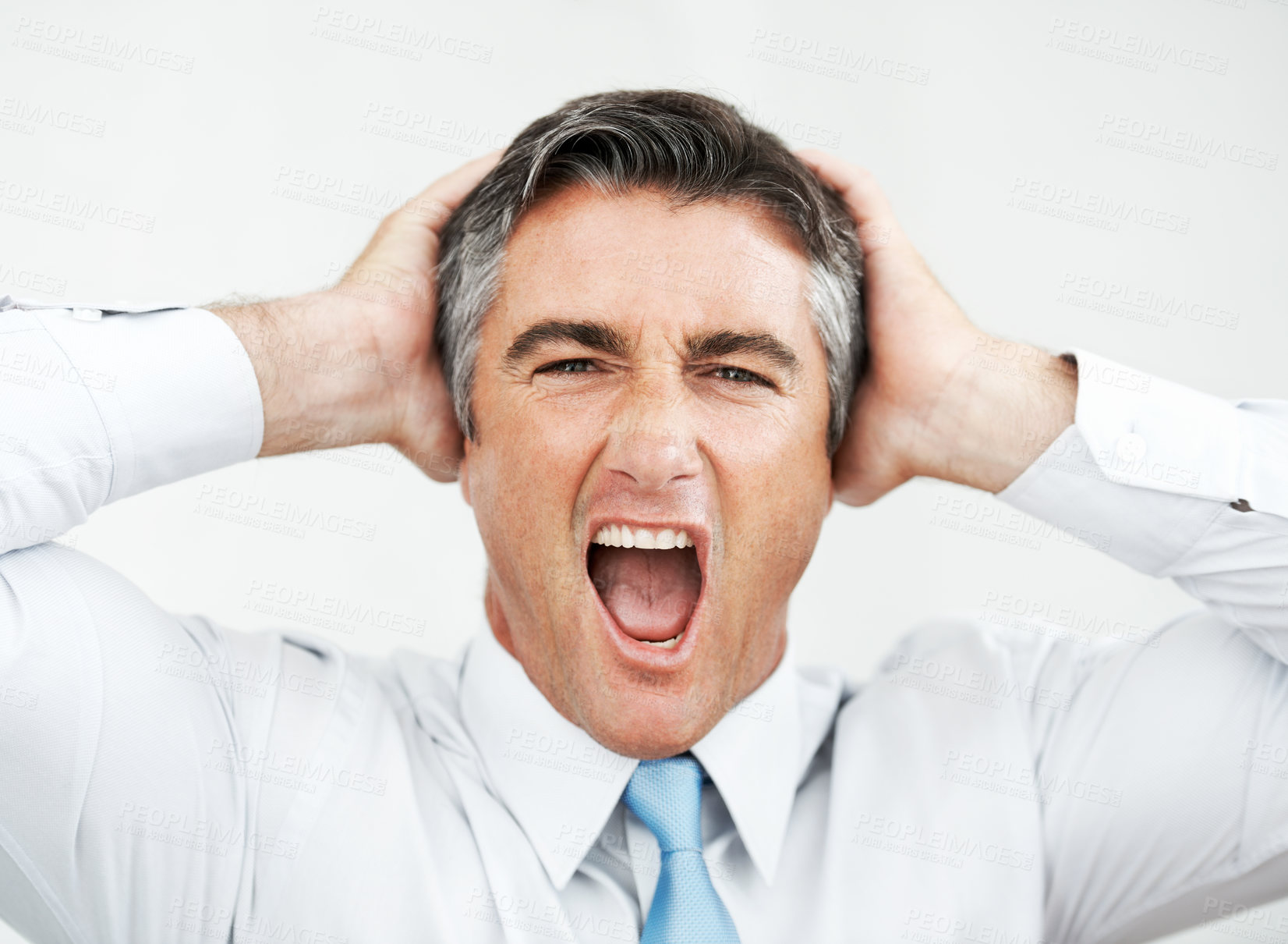 Buy stock photo Frustrated mature businessman with his hands on his head while yelling 