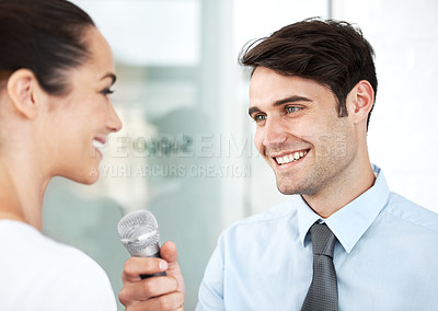 Buy stock photo Young executive being interviewed by a reporter with a microphone