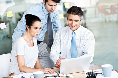 Buy stock photo Team, business people and laptop in office for planning, collaboration and ideas. Men and a woman together at a desk with tech and internet for corporate meeting, marketing or brainstorming strategy