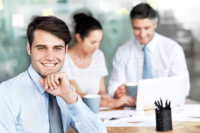 Buy stock photo Smiling young businessman sitting in a group meeting
