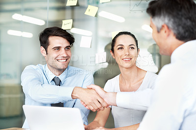 Buy stock photo Smiling businesspeople concluding a successful meeting together