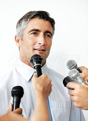 Buy stock photo Handsome mature businessman being interviewed against a white background