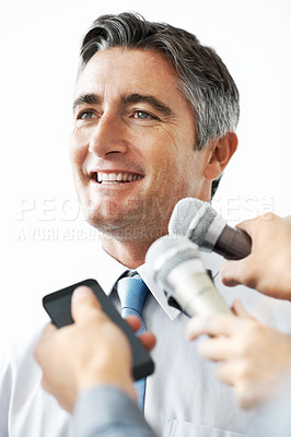 Buy stock photo Handsome mature businessman being interviewed against a white background