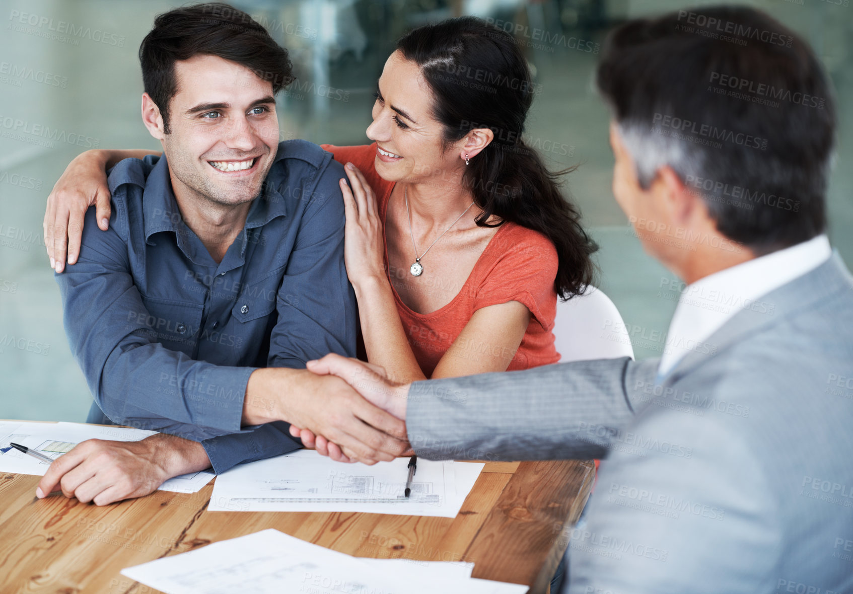 Buy stock photo Couple, handshake and documents in consultation with financial advisor for loan, agreement and contract. Happy, men and woman with gesture in discussion for finance investment, deal and thank you