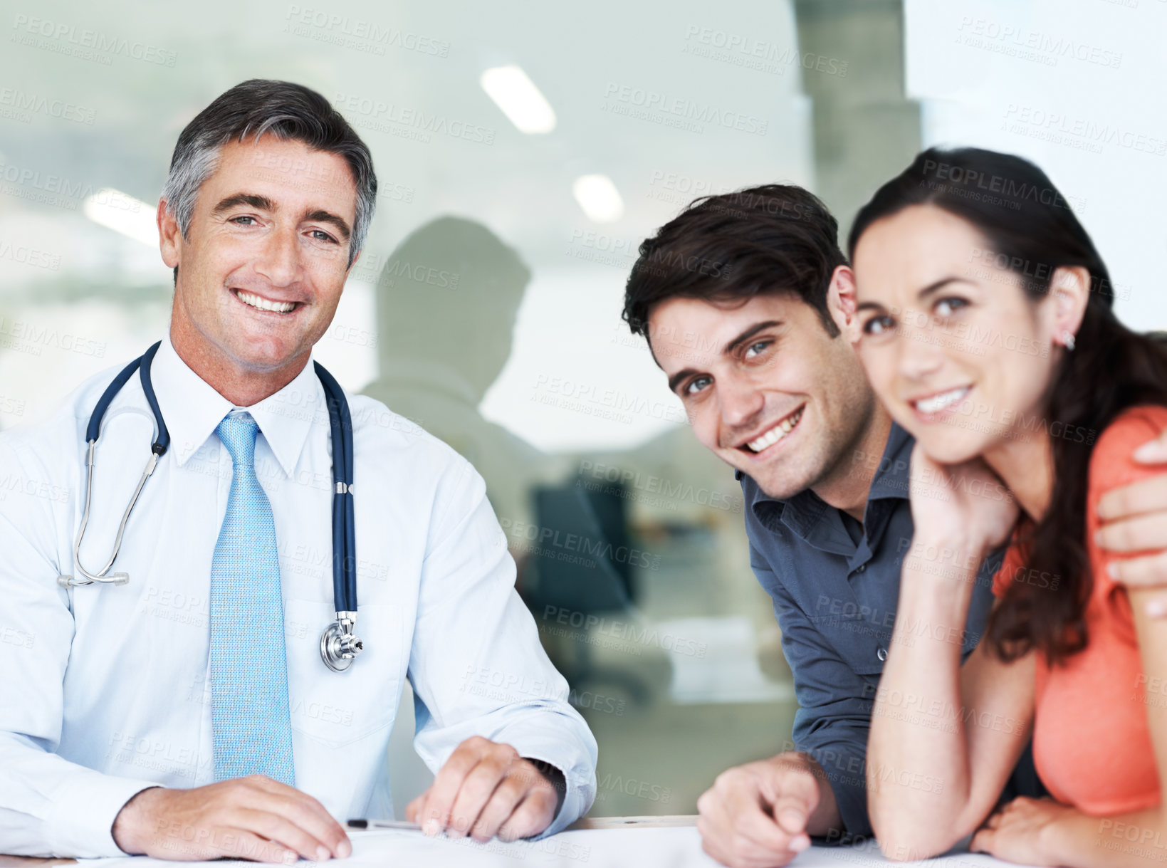 Buy stock photo Hospital, doctor and couple with documents in portrait for health insurance, premium and advisory. Clients, man and consultation with paperwork at desk for benefit option, info and medical coverage