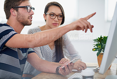 Buy stock photo Shot of two coworkers working at a computer in an office