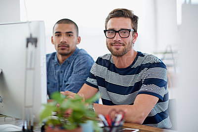 Buy stock photo Portrait of two coworkers sitting at a computer in an office