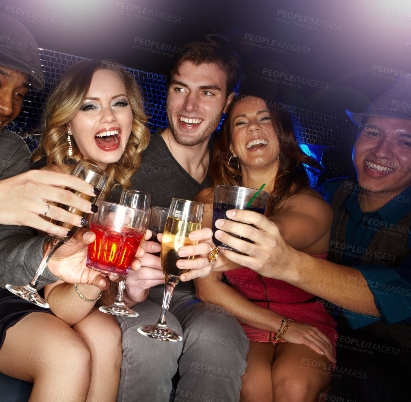 Buy stock photo An excited group of friends celebrating and drinking champagne together