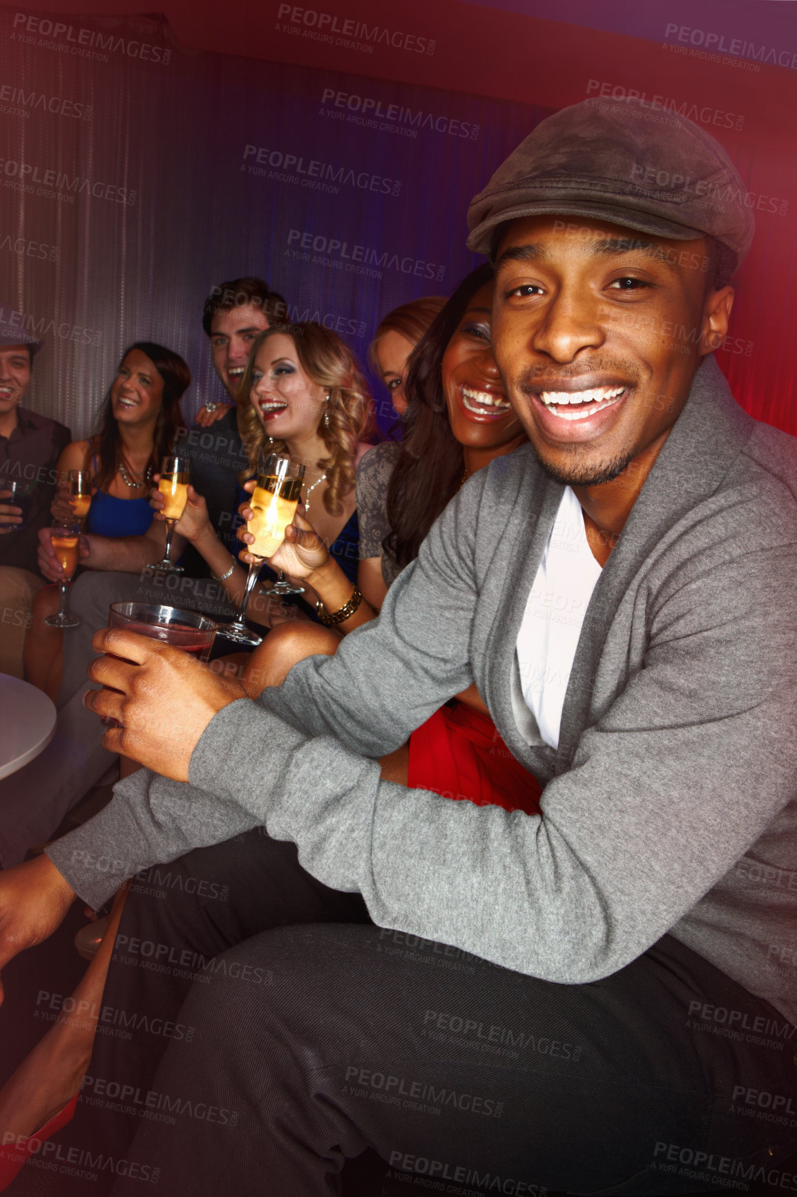 Buy stock photo A handsome african american man smiling happily while out clubbing with his friends