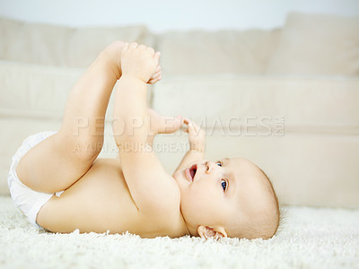 Buy stock photo Cute baby boy lying on the ground and looking around with curiosity and wonder