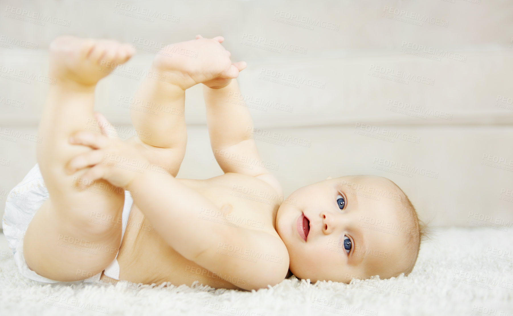 Buy stock photo Cute baby boy lying on the ground and looking around with curiosity and wonder