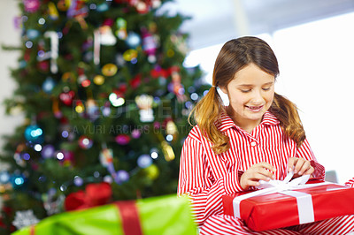 Buy stock photo Girl opening gift box for Christmas at family home, excited and happy with holiday spirit and celebration with present. Young child with gift, happiness and festive mood, tradition and celebrate.