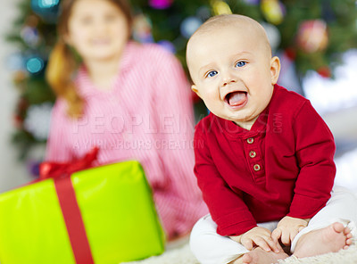 Buy stock photo Christmas, celebration and baby with a gift box, happy holiday and family tradition on the living room floor of a house. Festive energy, excited and portrait of a child with smile for present on xmas