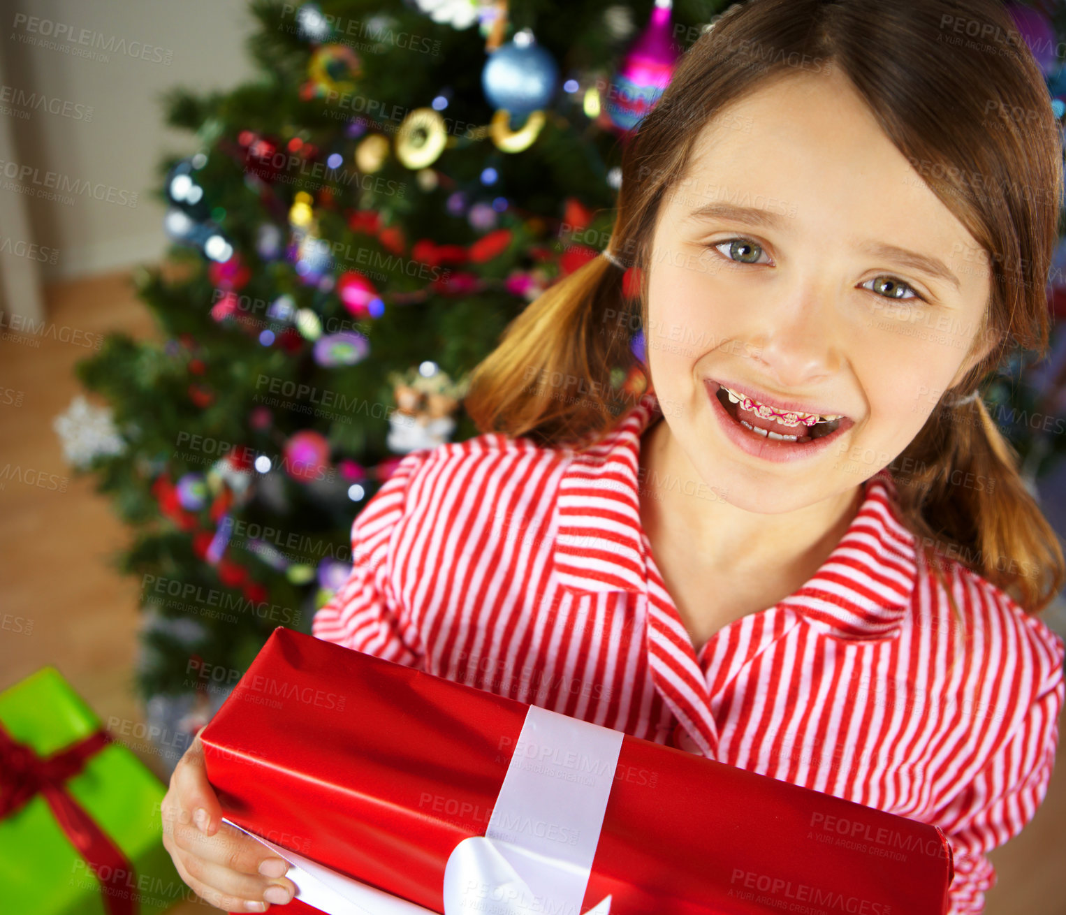 Buy stock photo Christmas, girl and gift for celebration, excited and festive season. Portrait, braces and female child enjoy presents,  happiness and vacation for Xmas, break and holiday to relax, joy and in lounge