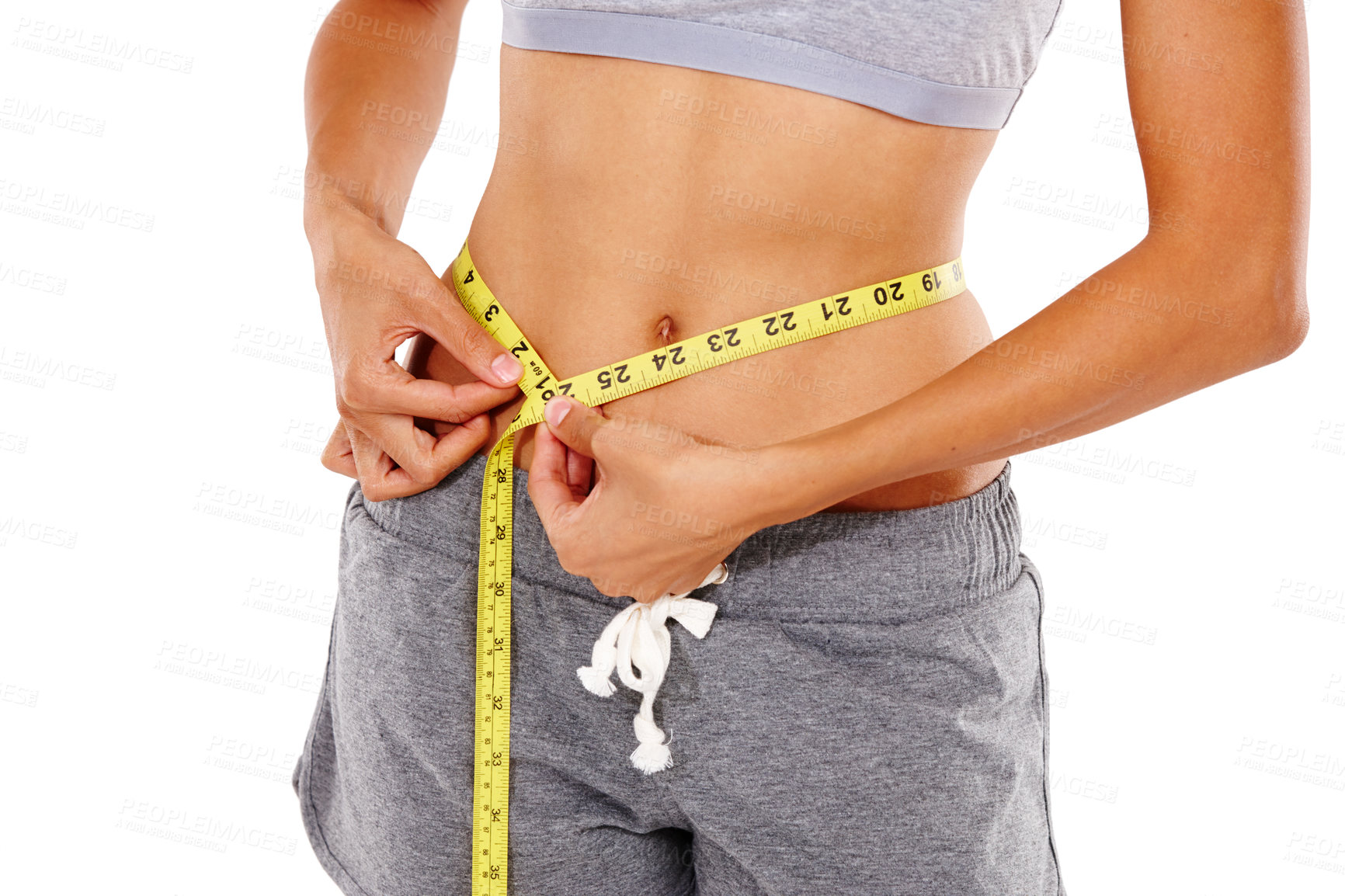 Buy stock photo Cropped shot of a woman measuring her waist with a measuring tape against a white background