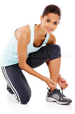 Buy stock photo Portrait of an attractive young woman in gymwear tying her shoe 
