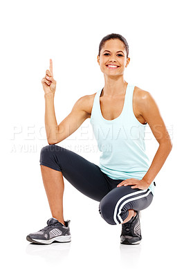 Buy stock photo Portrait of a beautiful young woman in gymwear crouching down and pointing upwards