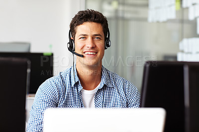 Buy stock photo A handsome young telecommunications operative sitting at his desk