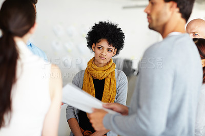 Buy stock photo A group of young employees talking over some paperwork