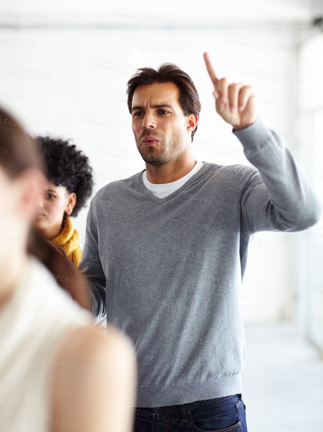 Buy stock photo Team, meeting and man with doubt, question and frustrated employee protest at creative agency. Workshop, human resources and business people at seminar with hand up, anger and confused in office.